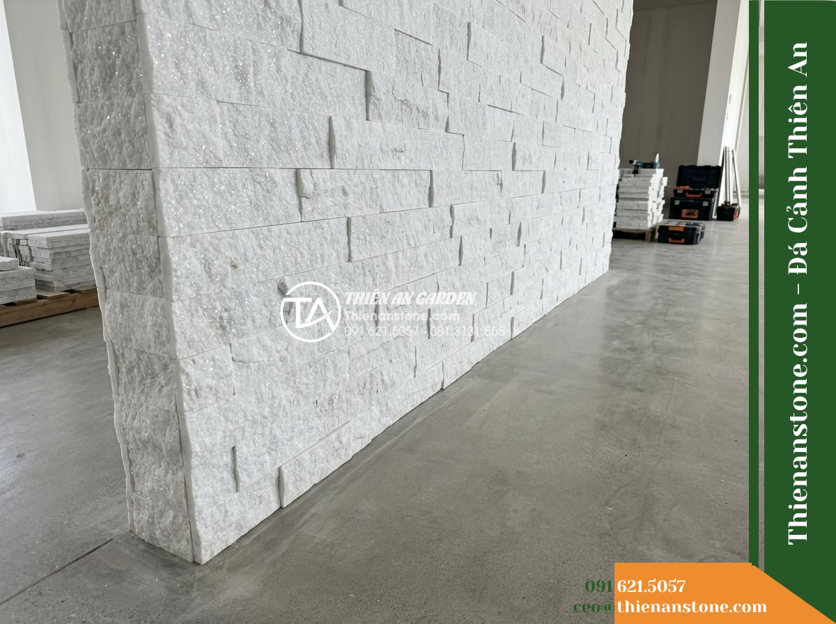Đá ghép trắng ánh kim Yên Bái | Thạch anh / Marble trắng Yên Bái | 10x50 cm - Hình 10 Đá ghép trắng ánh kim Yên Bái | Thạch anh / Marble trắng Yên Bái | 10x50 cm - Wide view of a feature wall base and surrounding floor area, showing accessibili