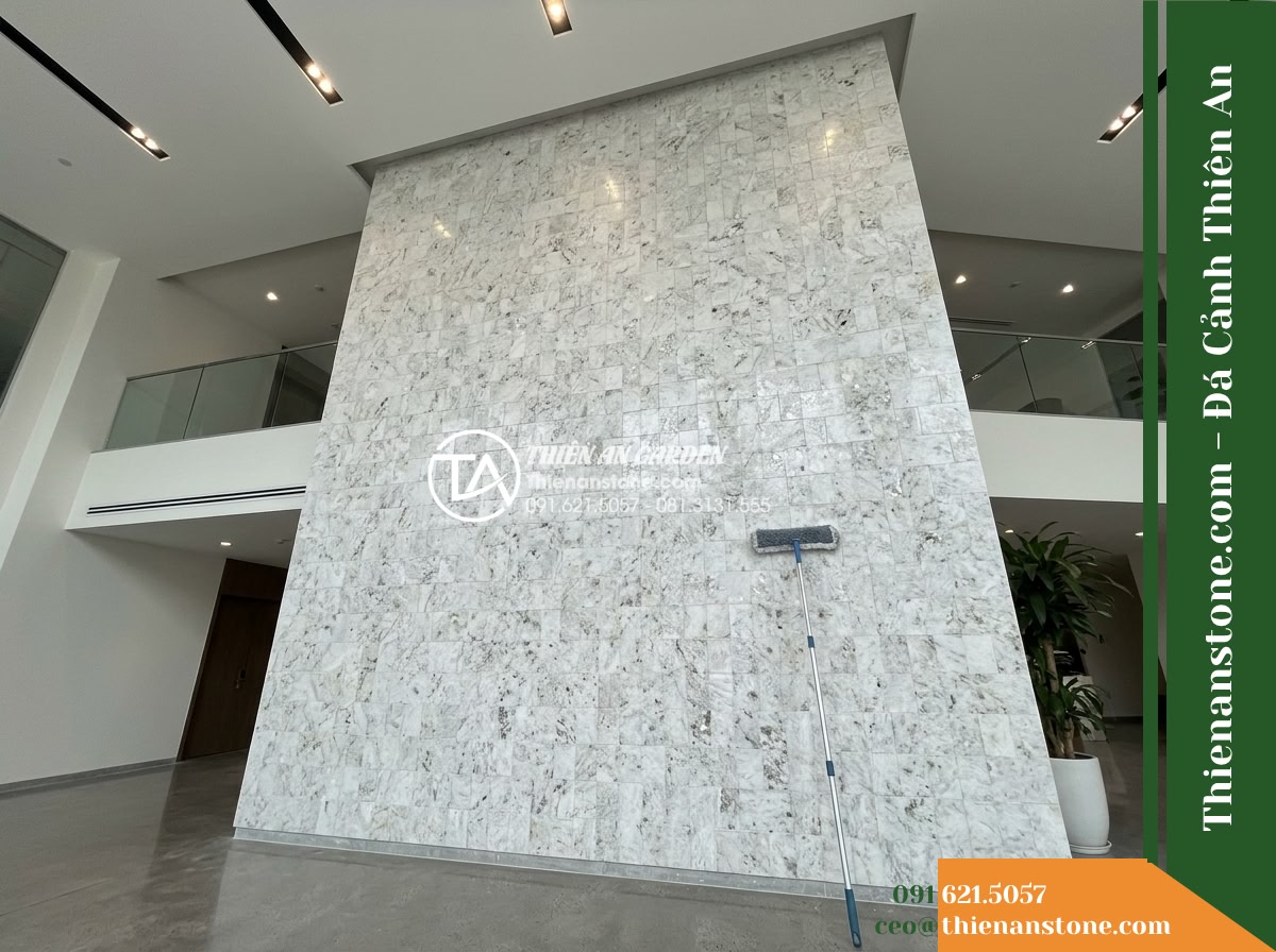 Đá ghép trắng ánh kim Yên Bái | Thạch anh / Marble trắng Yên Bái | 10x50 cm - Hình 16 Đá ghép trắng ánh kim Yên Bái | Thạch anh / Marble trắng Yên Bái | 10x50 cm - Wide architectural shot showing base footing and upper trim of a tall stone acce