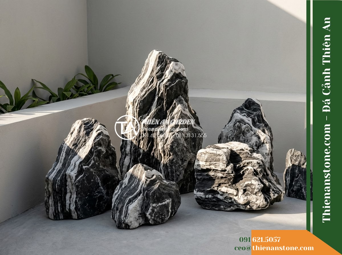 Đá Ngũ Vân Sơn (Size vừa 25–50cm) | Chuyên dựng hòn non bộ vừa. - Hình 13 Đá Ngũ Vân Sơn (Size vừa 25–50cm) | Chuyên dựng hòn non bộ vừa. - Side sunlight skimming across angular mountain stone surfaces in a minimalist co