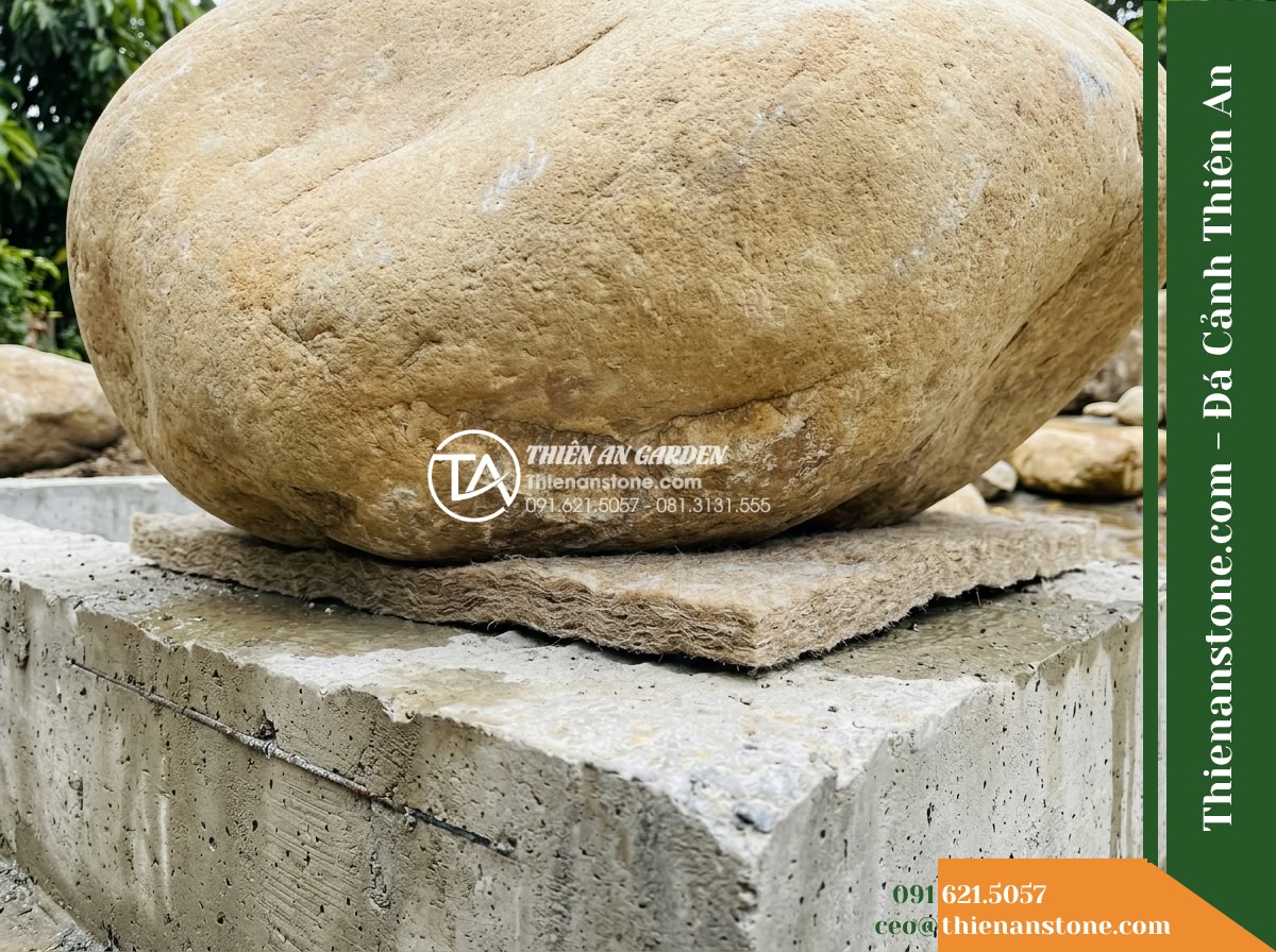 Đá Niên Thủy (Cuội đại 80–150cm / ~0.5–2 tấn) | Chuyên làm gò đất thấp, bãi đá ngầm chặn dòng dưới chân thác non bộ. - Hình 10 Đá Niên Thủy (Cuội đại 80–150cm / ~0.5–2 tấn) | Chuyên làm gò đất thấp, bãi đá ngầm chặn dòng dưới chân thác non bộ. - Ground-level view capturing the precise seating of a massive raw boulder onto a
