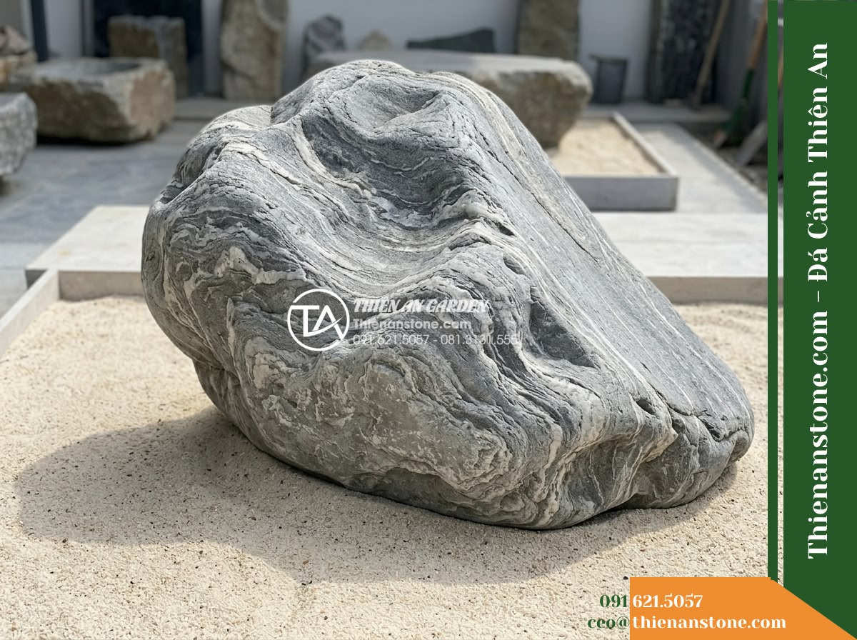 Đá Niên Thủy (Cuội lớn 40–70cm) | Chuyên bo bờ suối, tạo viền cảnh quan. - Hình 4 Đá Niên Thủy (Cuội lớn 40–70cm) | Chuyên bo bờ suối, tạo viền cảnh quan. - A side-profile architectural photo of a 60cm boulder placed on a display sandbed