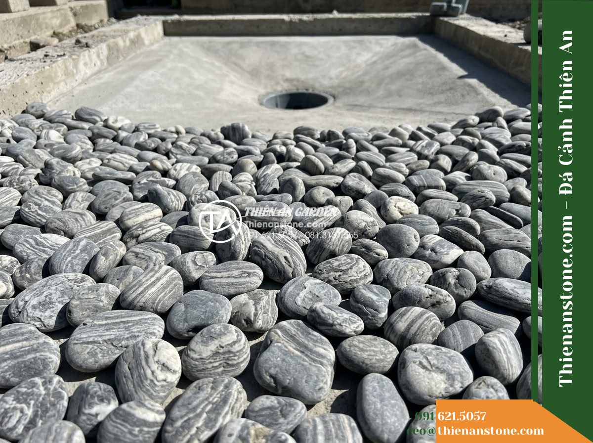 Đá Niên Thủy (Sỏi nhỏ 2–5cm) | Chuyên rải đáy hồ cá Koi. - A detailed horizontal shot of a newly constructed modern Koi pond bottom during