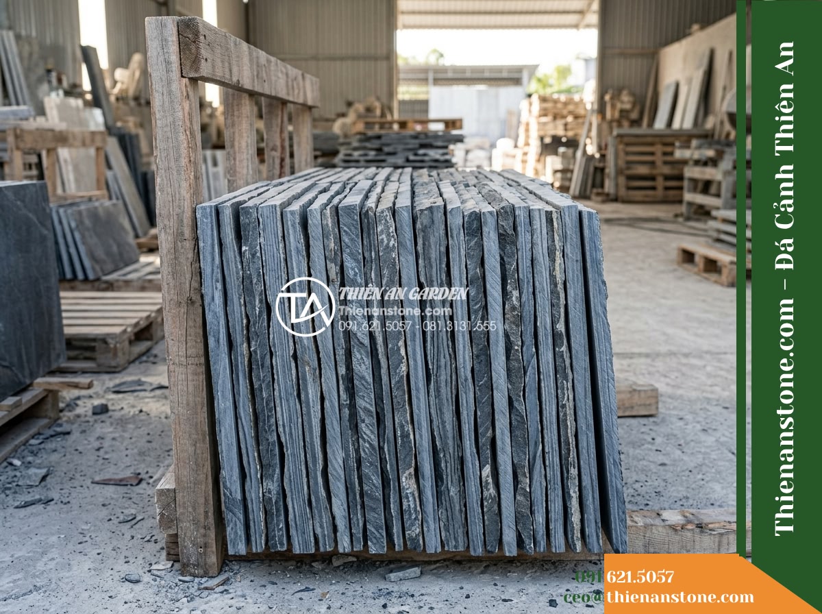 Đá Ông Phú (Tấm 20x40cm) | Chuyên ốp vách tường hồ, làm mảng tường trang trí cảnh quan. - Hình 4 Đá Ông Phú (Tấm 20x40cm) | Chuyên ốp vách tường hồ, làm mảng tường trang trí cảnh quan. - Side profile view of a stacked batch of 20x40cm stone slabs leaning on a timber