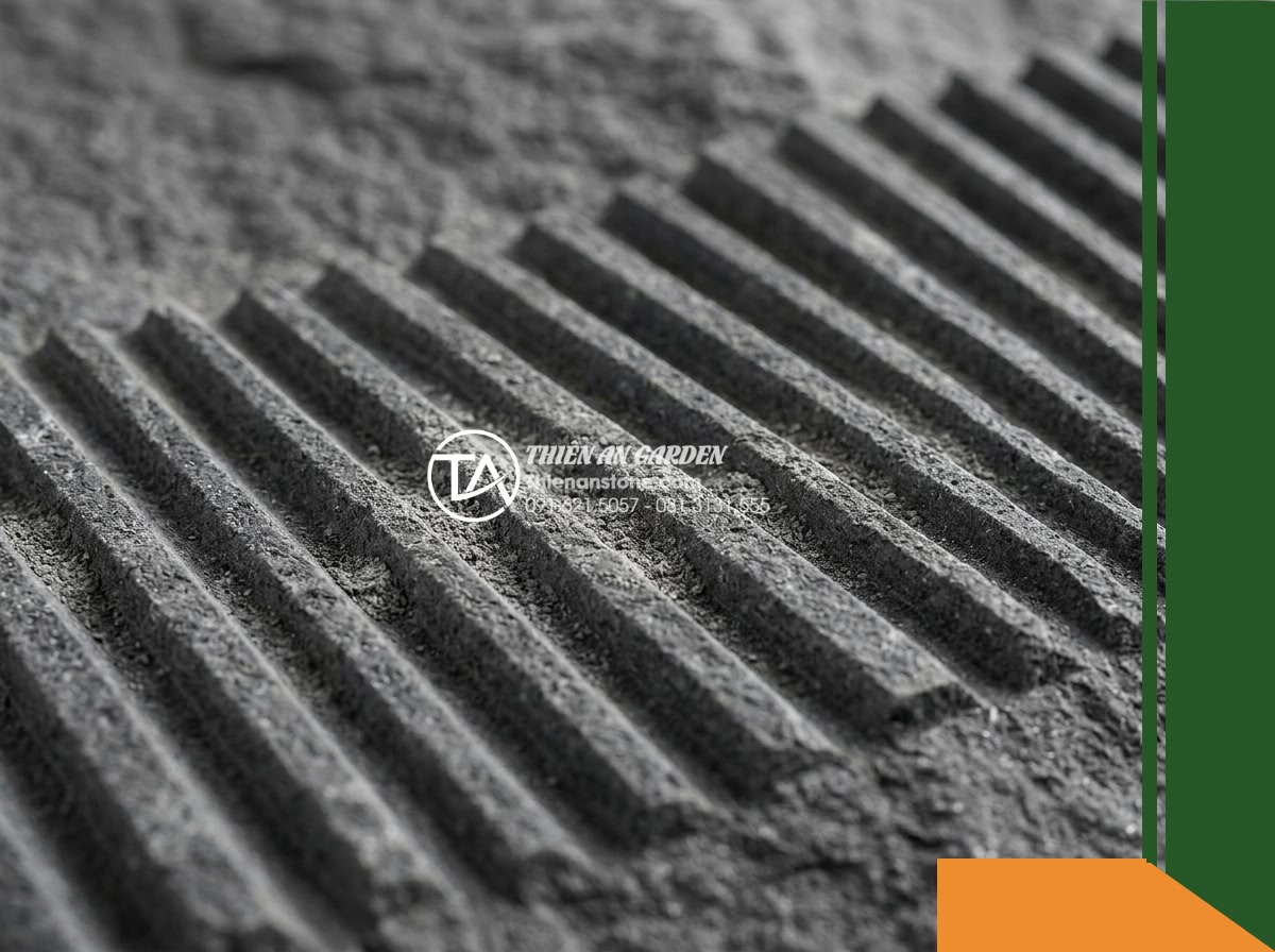 Đá răng lược bazan Gia Lai | Bazan xám đen Gia Lai | 10x50 cm - Hình 3 Đá răng lược bazan Gia Lai | Bazan xám đen Gia Lai | 10x50 cm - A macro close-up shot of the raw surface texture of dark grey Gia Lai basalt sto