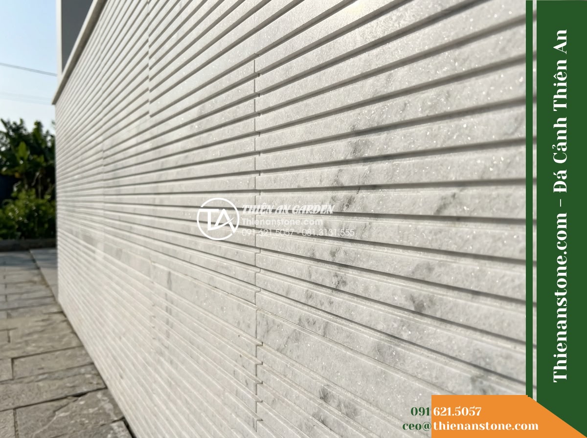 Đá răng lược trắng Nghệ An | Marble trắng Nghệ An | 10x50 cm - Hình 13 Đá răng lược trắng Nghệ An | Marble trắng Nghệ An | 10x50 cm - Daylight outdoor view of a white combed marble wall, showing soft natural shadow