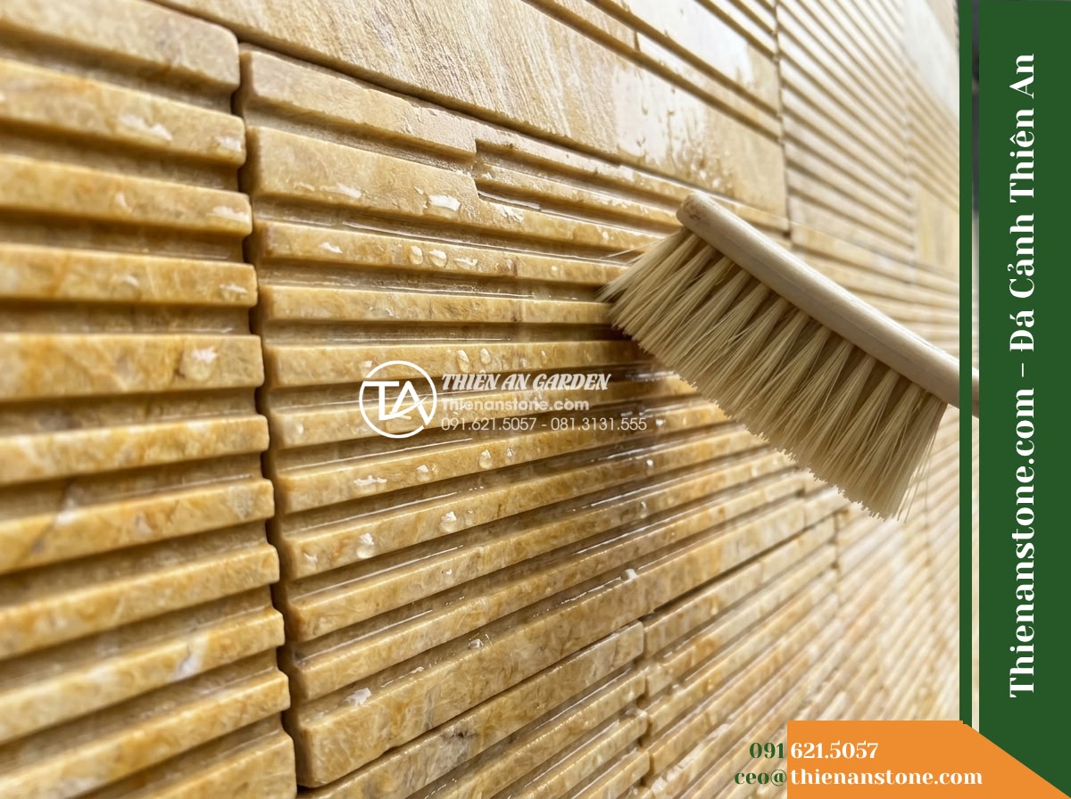 Đá răng lược vàng Nghệ An | Marble vàng Nghệ An | 10x50 cm - Hình 15 Đá răng lược vàng Nghệ An | Marble vàng Nghệ An | 10x50 cm - A close-up detail shot of the stone wall surface showing cleaning inspection, a