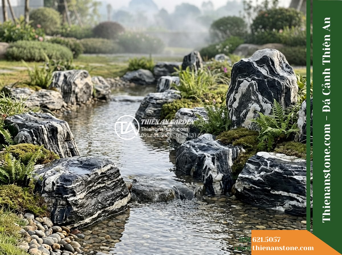 Đá Tuyết Lĩnh (Size vừa 35–60cm) | Chuyên xếp dòng chảy, tiểu cảnh sơn thủy. - A serene outdoor landscape featuring a gentle winding stream bordered by medium-