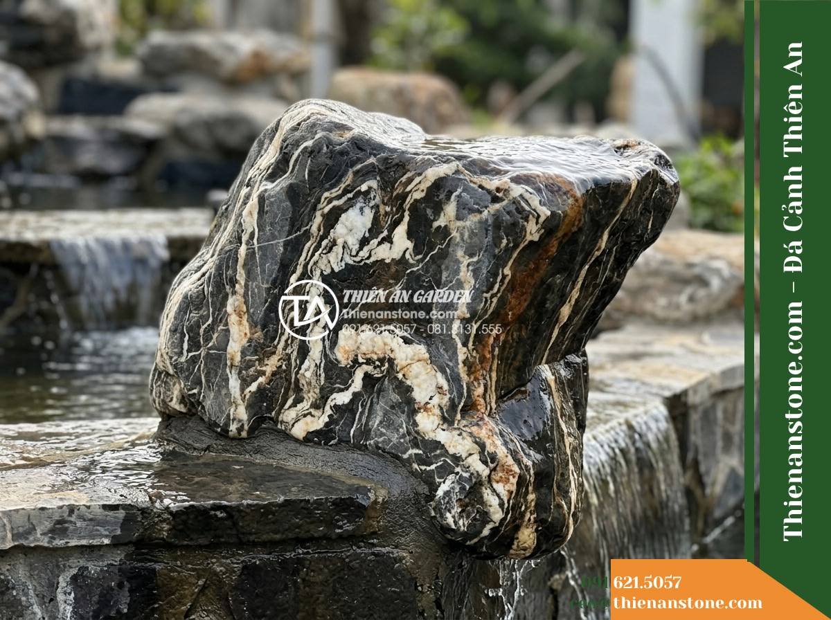 Đá Vũ Mây Thạch (Khối vừa 50–80cm) | Chuyên xếp tầng đổ nước thác. - Hình 2 Đá Vũ Mây Thạch (Khối vừa 50–80cm) | Chuyên xếp tầng đổ nước thác. - Side profile view of a medium 50-80cm landscape stone resting securely on a lowe