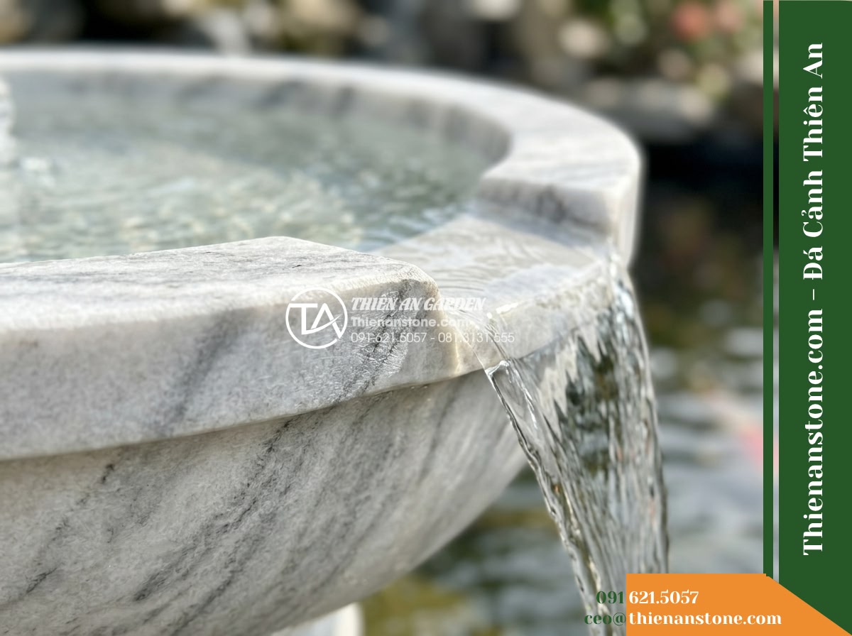 Đài Phun 2 Bát Tròn Chảy Tràn Hồ Koi, Bát D60cm Cao 1m - Hình 3 Đài Phun 2 Bát Tròn Chảy Tràn Hồ Koi, Bát D60cm Cao 1m - Macro focus on the hand-carved natural stone rim of a circular fountain basin, h