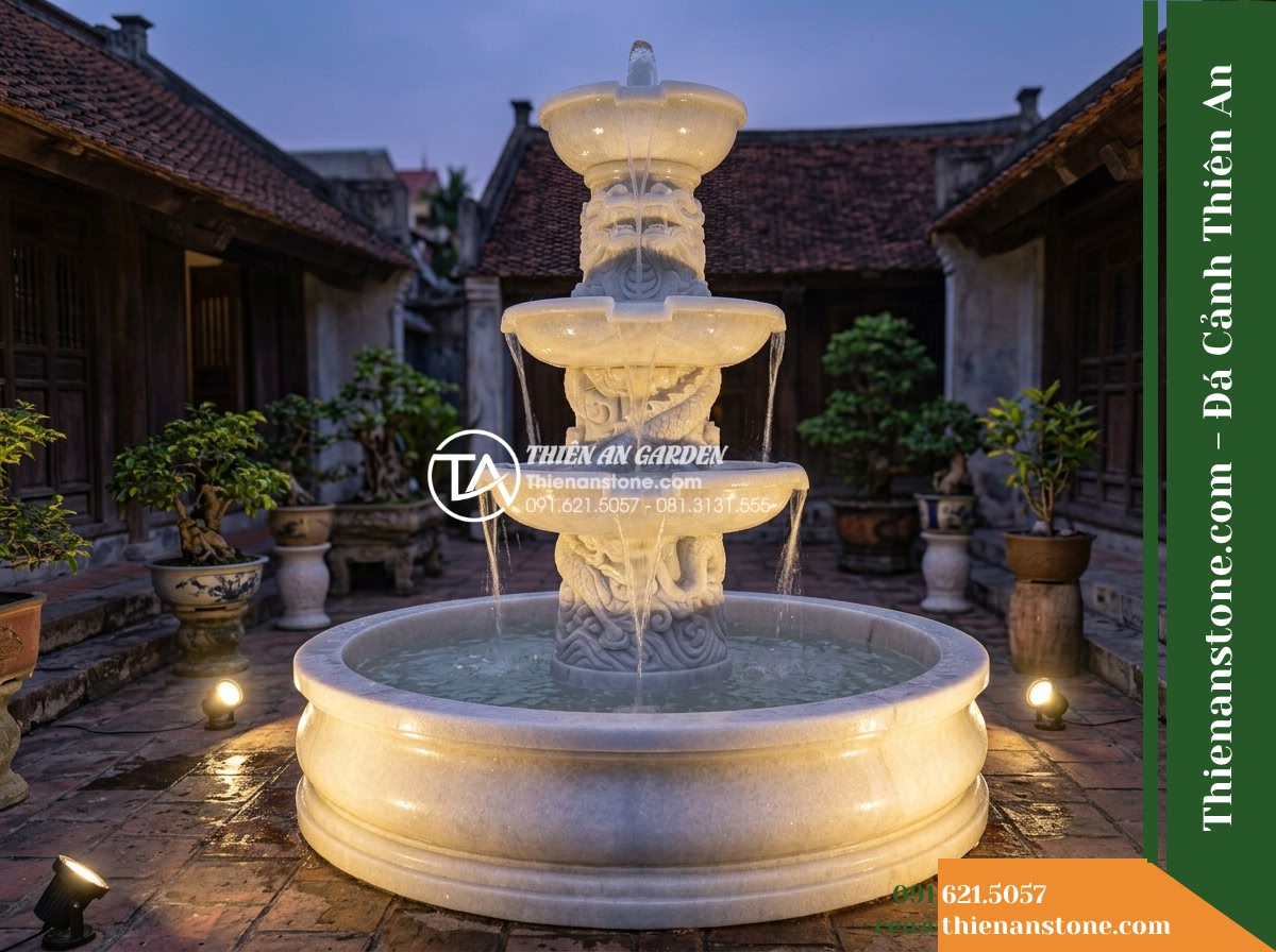 Đài Phun 3 Tầng Trụ Chạm Rồng Bán Diện, Bát D1.4m Cao 2m - Hình 14 Đài Phun 3 Tầng Trụ Chạm Rồng Bán Diện, Bát D1.4m Cao 2m - Evening twilight view of the fountain in a traditional courtyard, illuminated by