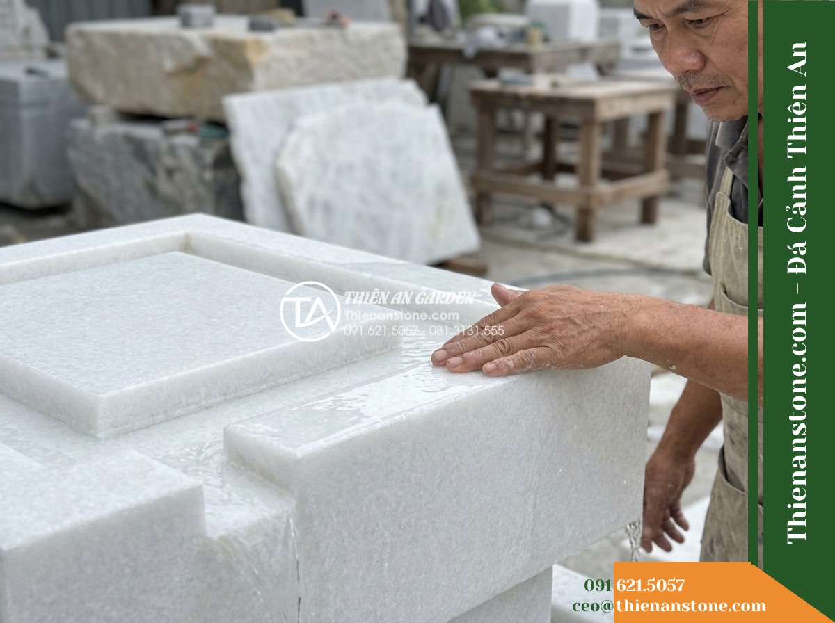 Đài Phun Bát Vuông 2 Tầng Tràn Bốn Góc, Bát D70cm Cao 1m - Hình 15 Đài Phun Bát Vuông 2 Tầng Tràn Bốn Góc, Bát D70cm Cao 1m - A close-up shot of a stonemason inspecting the clean chiseled edge of a stone sp
