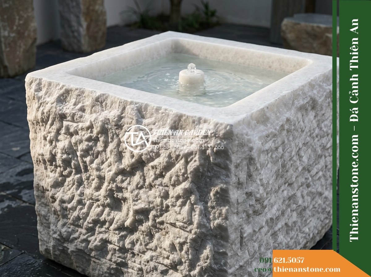 Đài Phun Bát Vuông Lòng Mài Mịn Vỏ Thô, Bát D80cm Cao 75cm - Hình 13 Đài Phun Bát Vuông Lòng Mài Mịn Vỏ Thô, Bát D80cm Cao 75cm - Raking side lighting capturing the deep textural chisel marks and shadows on the