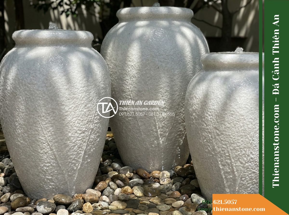 Đài Phun Cụm 3 Lu Nước Sân Vườn, D40cm Cao 60-80-100cm - Hình 2 Đài Phun Cụm 3 Lu Nước Sân Vườn, D40cm Cao 60-80-100cm - A close-up angled shot focusing on the three stone jars of staggered heights, hi