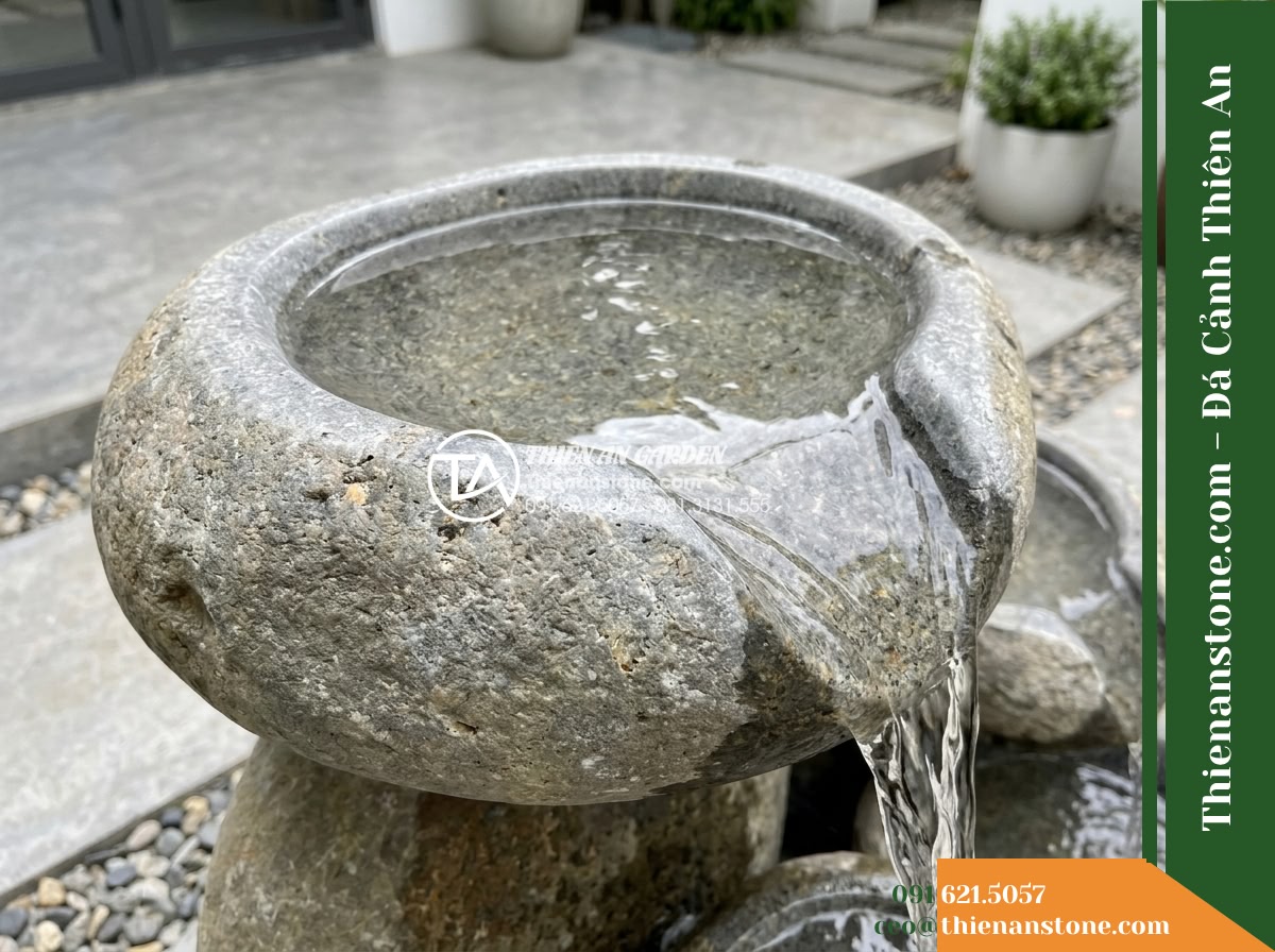Đài Phun Dáng Sỏi Suối Xếp Lệch Tầng, D80cm Cao 1m - Hình 15 Đài Phun Dáng Sỏi Suối Xếp Lệch Tầng, D80cm Cao 1m - A clear close-up maintenance-focused view showing the smooth, clean surface of t