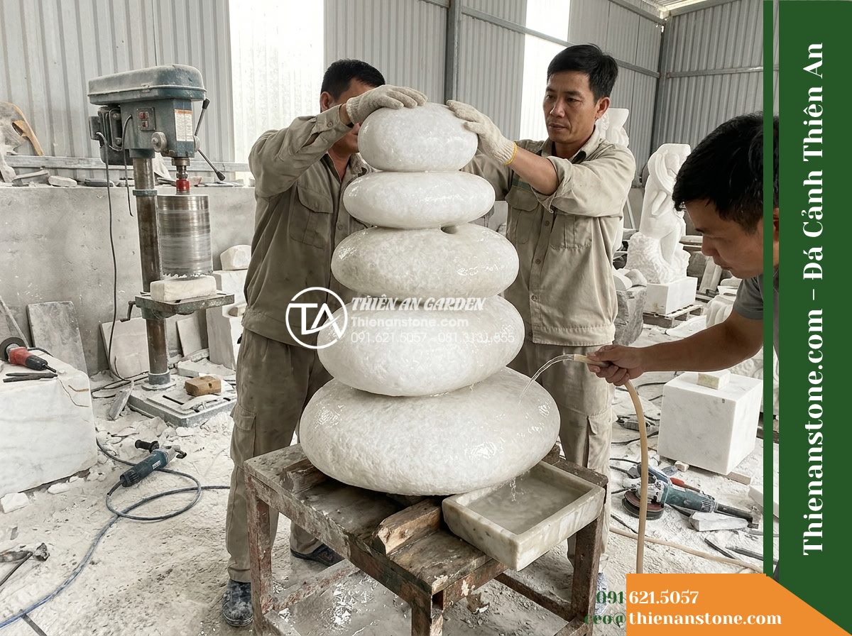Đài Phun Khối Suối Tròn Xếp Chồng, D80cm Cao 90cm - Hình 19 Đài Phun Khối Suối Tròn Xếp Chồng, D80cm Cao 90cm - A workshop photograph showing master stonemasons at Đá Cảnh Thiên An carefully h
