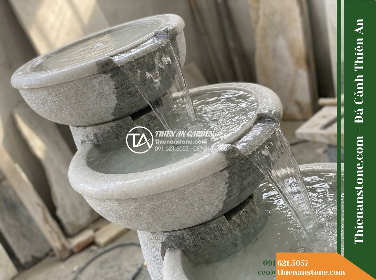 Đài Phun Tam Bát Nối Tiếp 3 Tầng, Bát D80cm Cao 1.1m - Hình 2 Đài Phun Tam Bát Nối Tiếp 3 Tầng, Bát D80cm Cao 1.1m - Diagonal close-up perspective of the three cascading round stone bowls, showcasi