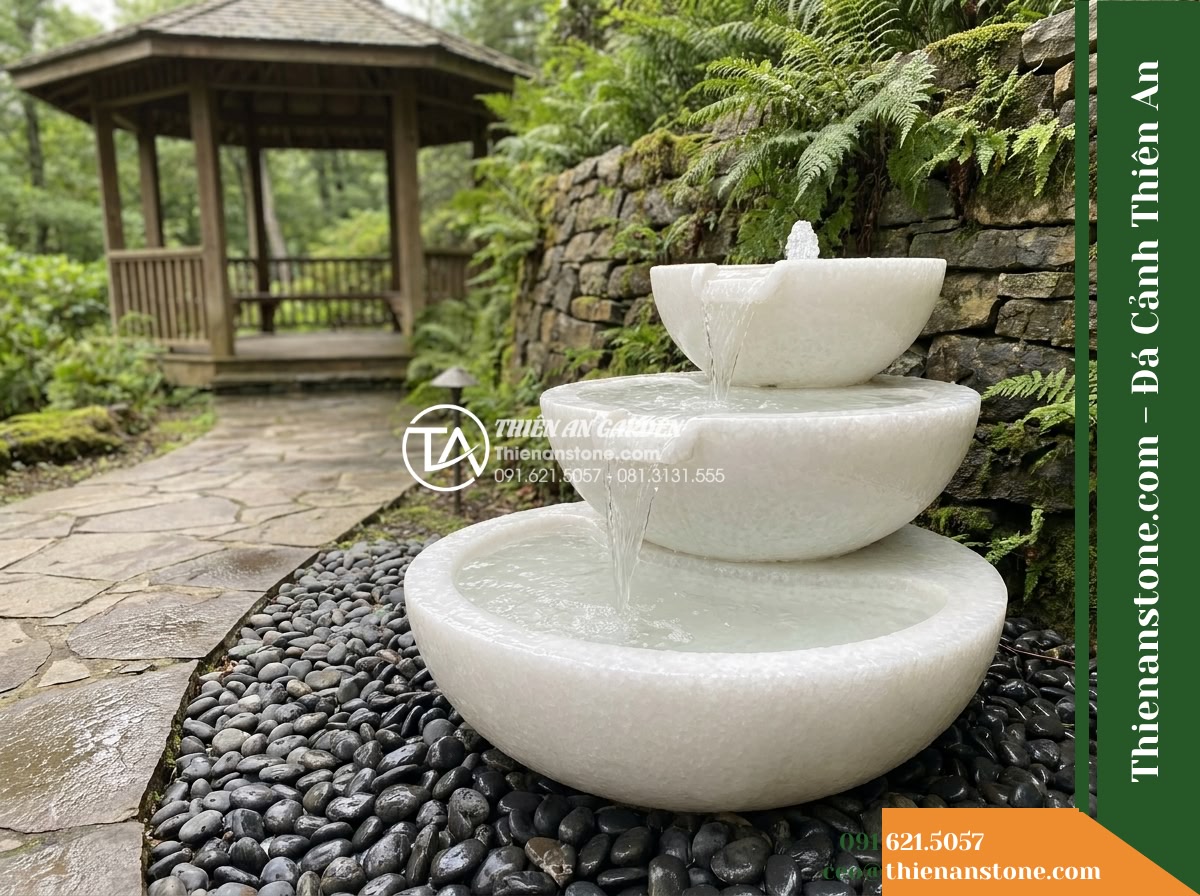 Đài Phun Tam Bát Nối Tiếp 3 Tầng, Bát D80cm Cao 1.1m - Hình 9 Đài Phun Tam Bát Nối Tiếp 3 Tầng, Bát D80cm Cao 1.1m - Photorealistic landscape view of the three-tier stone fountain nestled beside th