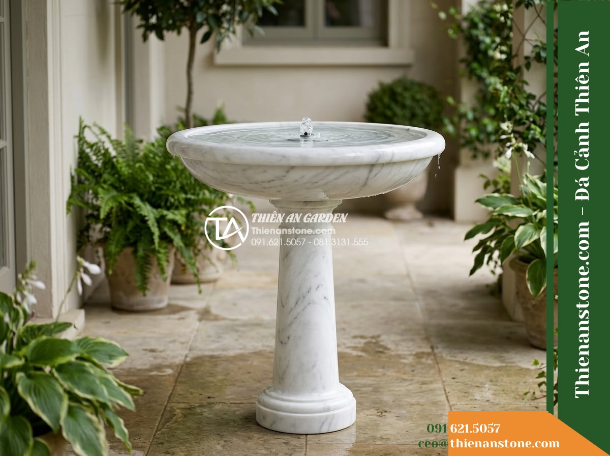 Đài Phun Trắng Mịn Vành Bo Tròn Lụa, Bát D80cm Cao 1.2m - Hình 1 Đài Phun Trắng Mịn Vành Bo Tròn Lụa, Bát D80cm Cao 1.2m - A refined white natural stone fountain standing on a compact private villa porch