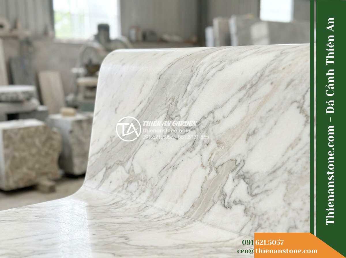 Ghế Đá Công Viên Có Tựa Bo Tròn Hòa Sơn 140x50x82cm - Đá Đen Cẩm Thạch - Hình 4 Ghế Đá Công Viên Có Tựa Bo Tròn Hòa Sơn 140x50x82cm - Đá Đen Cẩm Thạch - A black marble stone bench integrated into a Vietnamese luxury resort landscape