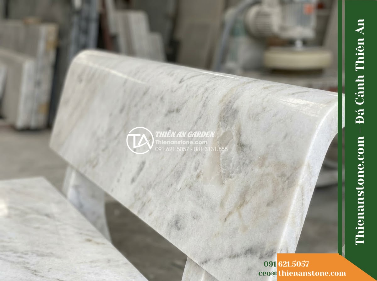 Ghế Đá Công Viên Có Tựa Cao Bản Lớn Đại Lộc 180x55x90cm - Đá Vàng Cẩm Thạch - Hình 3 Ghế Đá Công Viên Có Tựa Cao Bản Lớn Đại Lộc 180x55x90cm - Đá Vàng Cẩm Thạch - A golden marble stone bench at golden hour, warm sunset light casting long shado