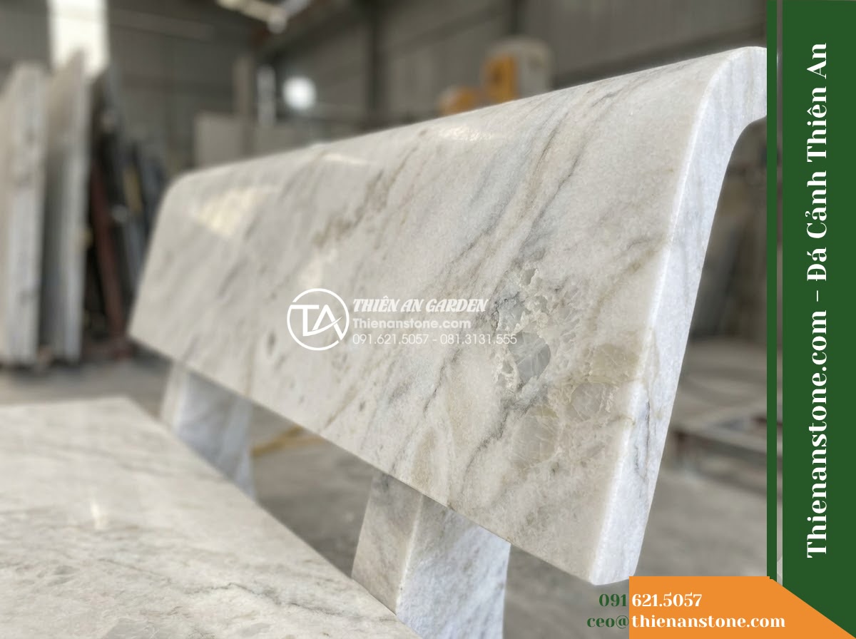 Ghế Đá Công Viên Có Tựa Cao Bản Lớn Đại Lộc 180x55x90cm - Đá Vàng Cẩm Thạch - Hình 4 Ghế Đá Công Viên Có Tựa Cao Bản Lớn Đại Lộc 180x55x90cm - Đá Vàng Cẩm Thạch - A golden marble stone bench integrated into a Vietnamese luxury resort landscape