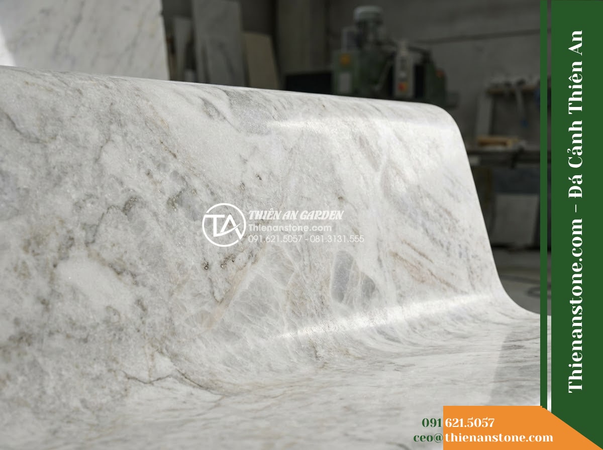 Ghế Đá Công Viên Có Tựa Cao Bản Lớn Đại Lộc 180x55x90cm - Đá Vàng Cẩm Thạch - Hình 5 Ghế Đá Công Viên Có Tựa Cao Bản Lớn Đại Lộc 180x55x90cm - Đá Vàng Cẩm Thạch - Professional installation of a golden marble stone bench in a landscaped garden,