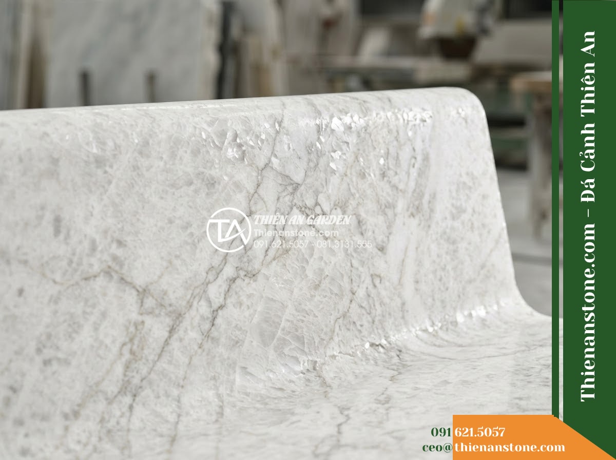 Ghế Đá Công Viên Có Tựa Lượn Sóng Trường Xuân 160x50x85cm - Đá Xanh Cẩm Thạch - Hình 5 Ghế Đá Công Viên Có Tựa Lượn Sóng Trường Xuân 160x50x85cm - Đá Xanh Cẩm Thạch - Professional installation of a green marble stone bench in a landscaped garden,