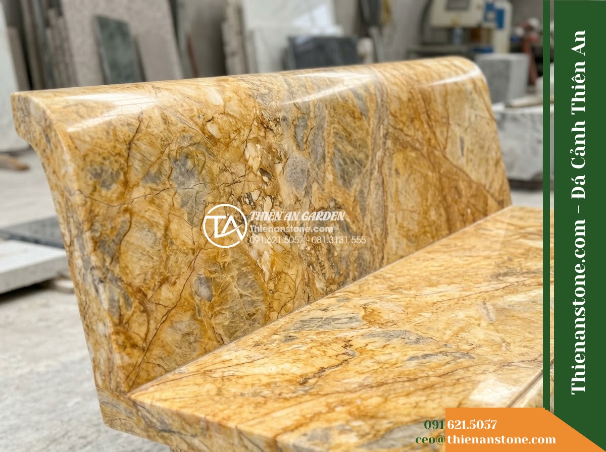 Ghế Đá Công Viên Có Tựa Tròn Viền Thanh Lộc 140x50x82cm - Đá Vàng Cẩm Thạch - Hình 4 Ghế Đá Công Viên Có Tựa Tròn Viền Thanh Lộc 140x50x82cm - Đá Vàng Cẩm Thạch - A golden marble stone bench integrated into a Vietnamese luxury resort landscape