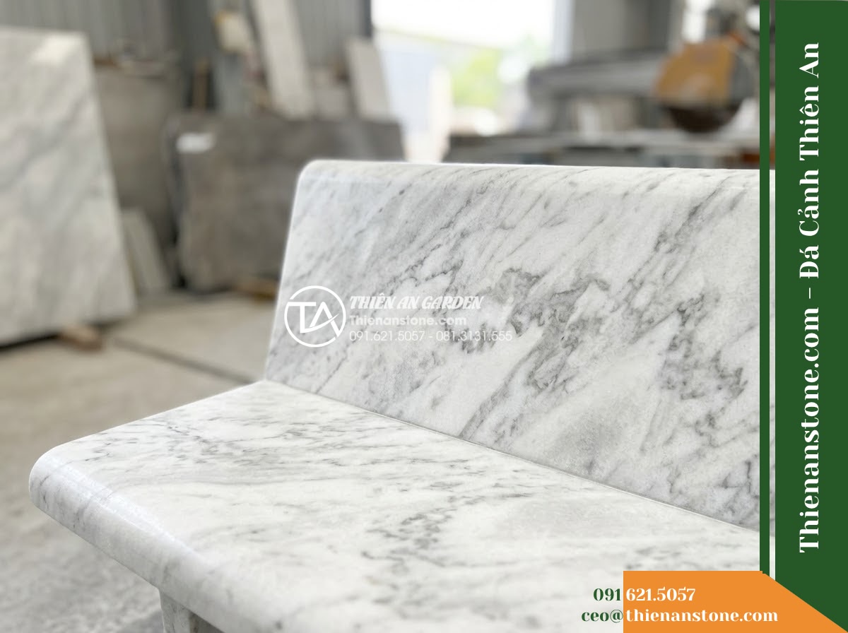 Ghế Đá Công Viên Có Tựa Tròn Viền Thanh Lộc 140x50x82cm - Đá Vàng Cẩm Thạch - Hình 5 Ghế Đá Công Viên Có Tựa Tròn Viền Thanh Lộc 140x50x82cm - Đá Vàng Cẩm Thạch - Professional installation of a golden marble stone bench in a landscaped garden,