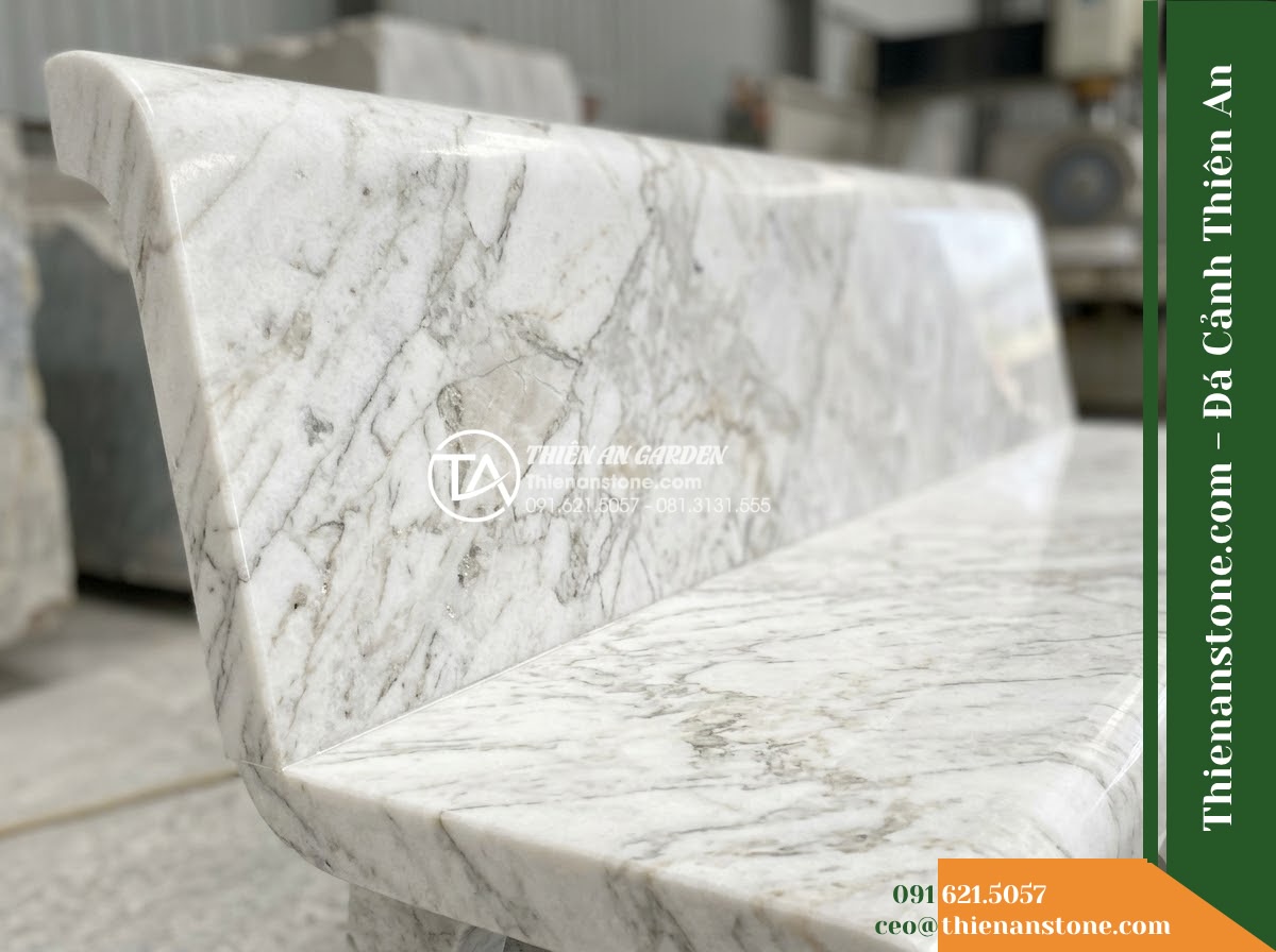 Ghế Đá Công Viên Có Tựa Vuông Đông Phương 180x55x90cm - Đá Xanh Cẩm Thạch - Hình 3 Ghế Đá Công Viên Có Tựa Vuông Đông Phương 180x55x90cm - Đá Xanh Cẩm Thạch - Stone bench of green marble beside a cascading water feature at night, illuminat