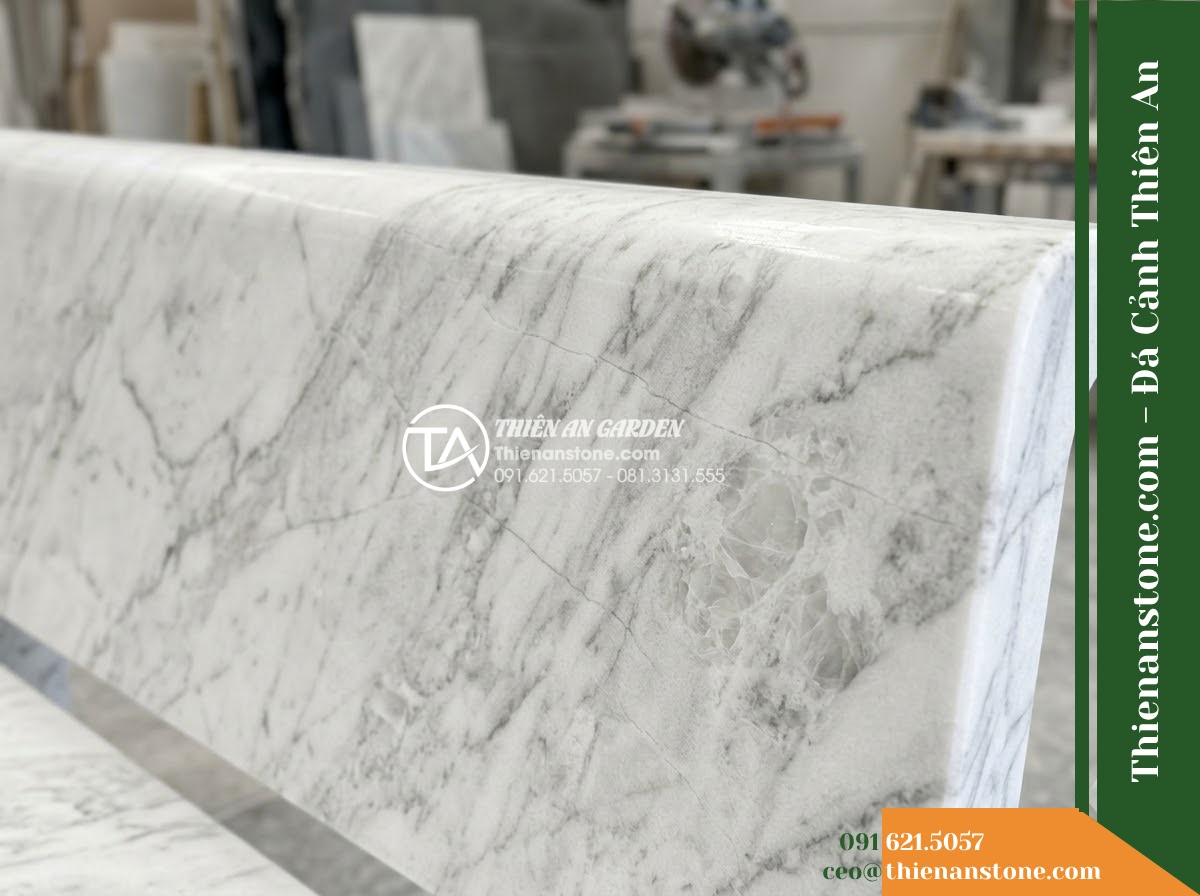 Ghế Đá Công Viên Không Tựa Bản Rộng Thịnh Vượng 180x55x45cm - Đá Vàng Cẩm Thạch - Hình 5 Ghế Đá Công Viên Không Tựa Bản Rộng Thịnh Vượng 180x55x45cm - Đá Vàng Cẩm Thạch - Professional installation of a golden marble stone bench in a landscaped garden,