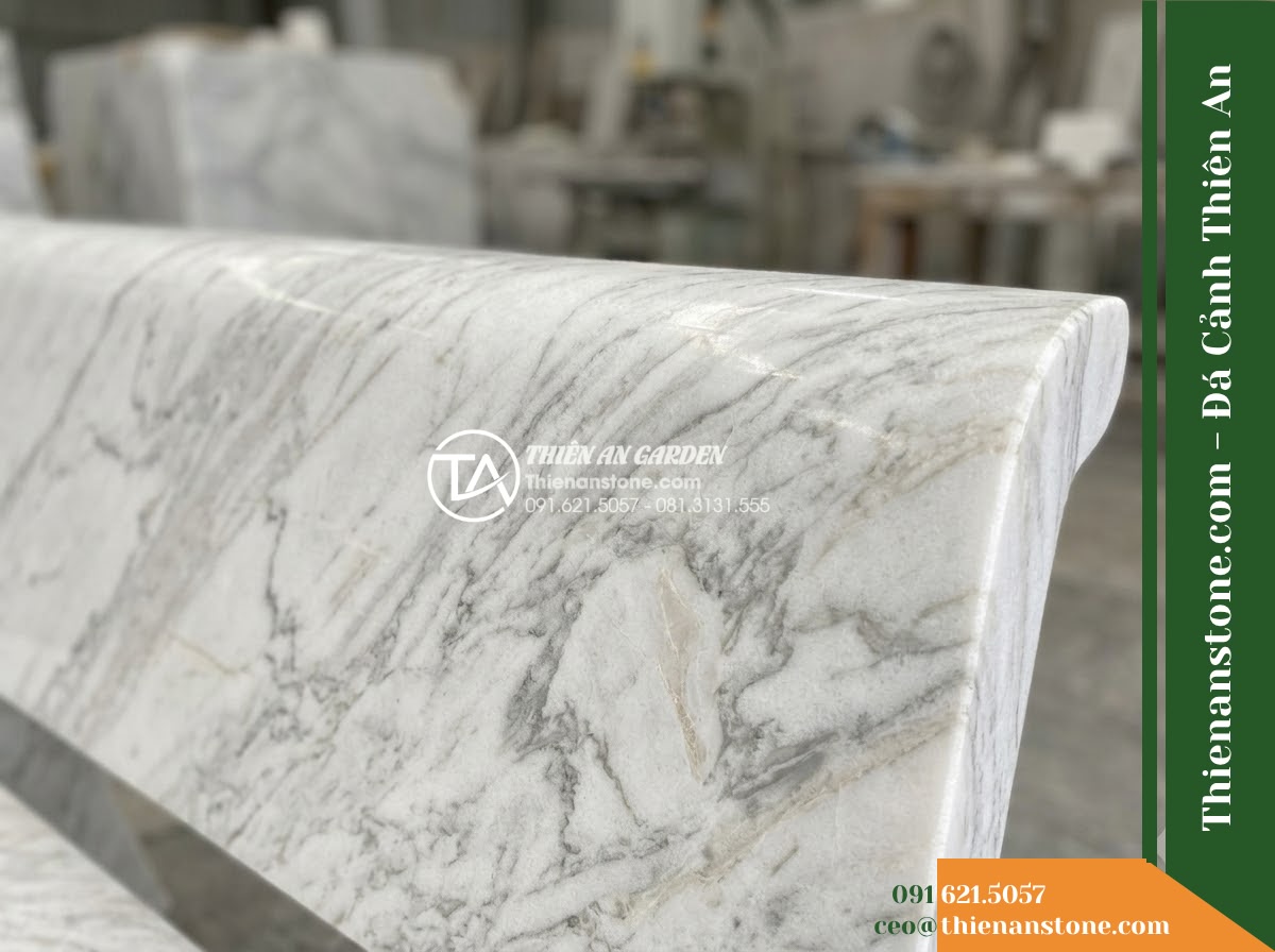 Ghế Đá Công Viên Không Tựa Chân Khối Phúc Thịnh 160x45x45cm - Đá Đen Cẩm Thạch - Hình 5 Ghế Đá Công Viên Không Tựa Chân Khối Phúc Thịnh 160x45x45cm - Đá Đen Cẩm Thạch - Professional installation of a black marble stone bench in a landscaped garden,
