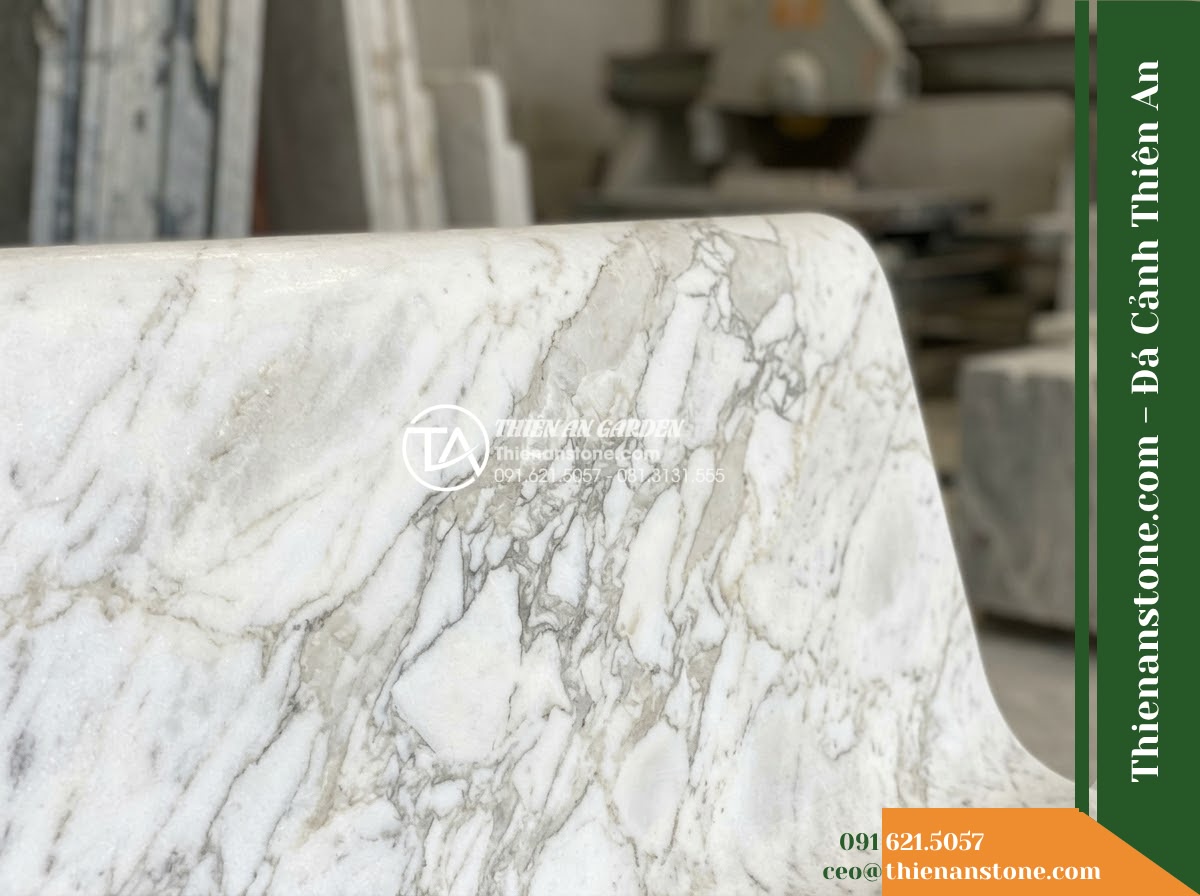 Ghế Đá Công Viên Không Tựa Chân Khối Trường Xuân 160x45x45cm - Đá Xanh Cẩm Thạch - Hình 3 Ghế Đá Công Viên Không Tựa Chân Khối Trường Xuân 160x45x45cm - Đá Xanh Cẩm Thạch - green marble stone bench flanked by potted bonsai trees on a resort terrace over