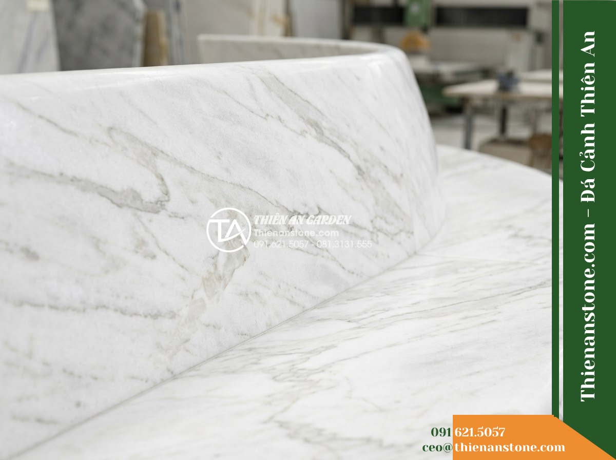 Ghế Đá Công Viên Không Tựa Chân Trụ Bảo An 150x45x45cm - Đá Vàng Cẩm Thạch - Hình 5 Ghế Đá Công Viên Không Tựa Chân Trụ Bảo An 150x45x45cm - Đá Vàng Cẩm Thạch - Professional installation of a golden marble stone bench in a landscaped garden,