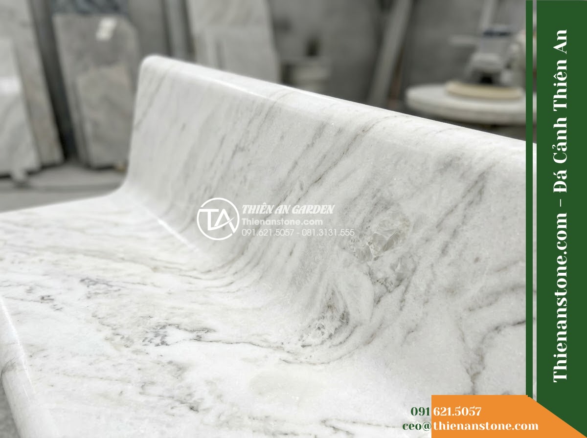 Ghế Đá Công Viên Không Tựa Khối Thấp Trường Lộc 140x50x40cm - Đá Đen Cẩm Thạch - Hình 5 Ghế Đá Công Viên Không Tựa Khối Thấp Trường Lộc 140x50x40cm - Đá Đen Cẩm Thạch - Professional installation of a black marble stone bench in a landscaped garden,
