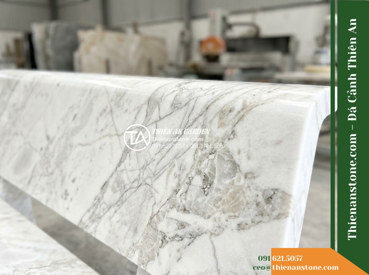 Ghế Đá Công Viên Không Tựa Liền Khối Vân Long 160x50x45cm - Đá Trắng Cẩm Thạch - Hình 5 Ghế Đá Công Viên Không Tựa Liền Khối Vân Long 160x50x45cm - Đá Trắng Cẩm Thạch - Professional installation of a white marble stone bench in a landscaped garden,