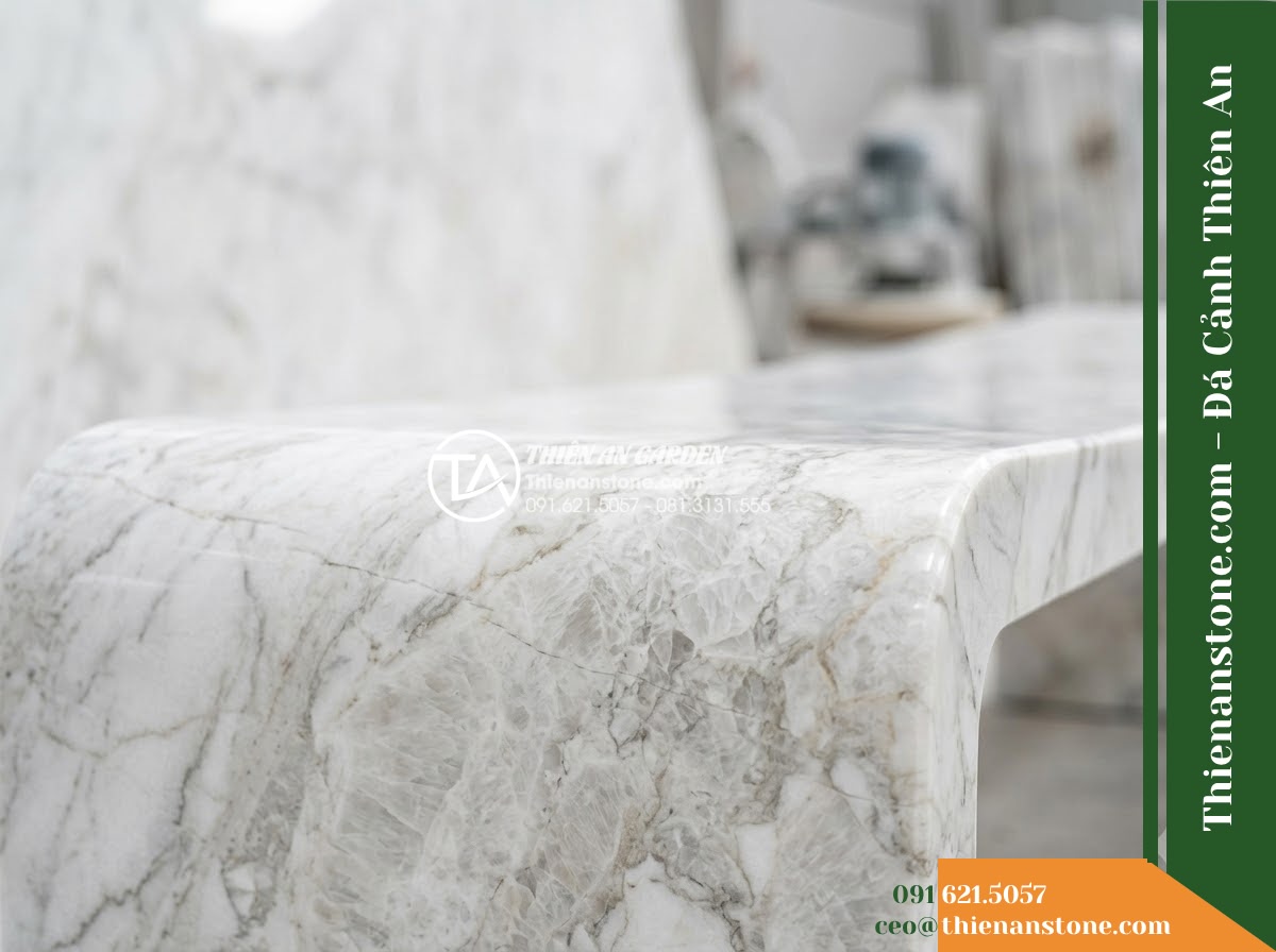 Ghế Đá Công Viên Không Tựa Mặt Cong Huyền Vũ 150x45x45cm - Đá Đen Cẩm Thạch - Hình 4 Ghế Đá Công Viên Không Tựa Mặt Cong Huyền Vũ 150x45x45cm - Đá Đen Cẩm Thạch - A black marble stone bench integrated into a Vietnamese luxury resort landscape