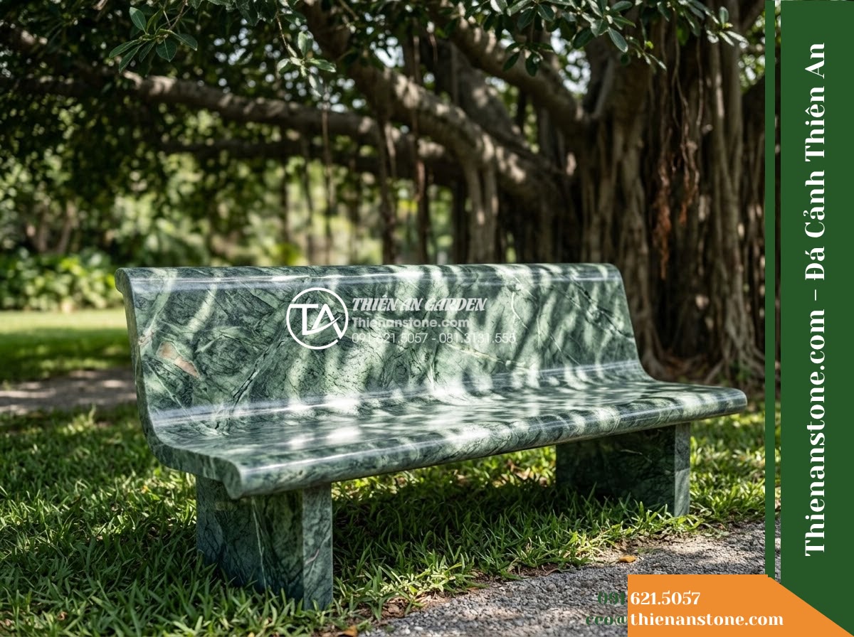 Ghế Đá Công Viên Không Tựa Mặt Cong Lam Viên 150x45x45cm - Đá Xanh Cẩm Thạch - Hình 2 Ghế Đá Công Viên Không Tựa Mặt Cong Lam Viên 150x45x45cm - Đá Xanh Cẩm Thạch - A beautifully crafted green marble stone bench under a large banyan tree, dapple