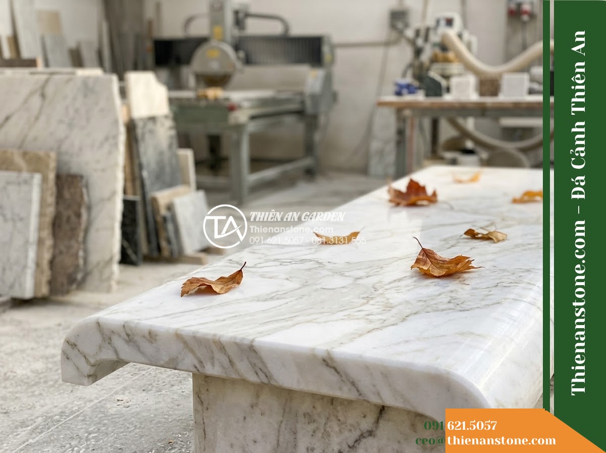 Ghế Đá Granite Nguyên Khối Hưng Thịnh – Kích thước 160 x 45 x 46 cm – Kiểu dáng khối hộp hiện đại, chân thu vào trong. Chất liệu đá granite - Hình 3 Ghế Đá Granite Nguyên Khối Hưng Thịnh – Kích thước 160 x 45 x 46 cm – Kiểu dáng khối hộp hiện đại, chân thu vào trong. Chất liệu đá granite - Autumn scene with fallen leaves scattered on a natural granite stone bench in a