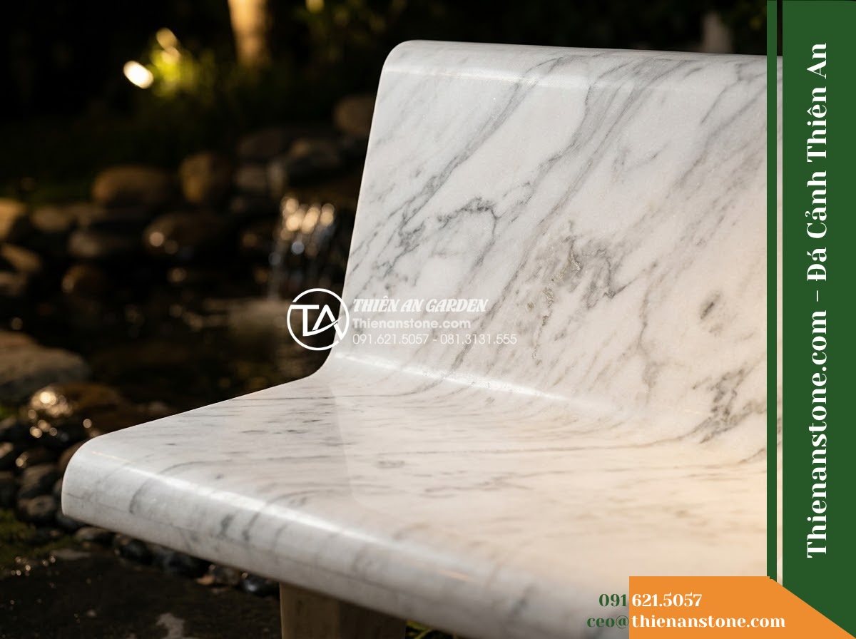 Ghế Đá Granite Nguyên Khối Long An – Kích thước 170 x 46 x 45 cm – Kiểu dáng mặt bo tròn, chân chữ U liền mạch. Chất liệu đá granite - Hình 3 Ghế Đá Granite Nguyên Khối Long An – Kích thước 170 x 46 x 45 cm – Kiểu dáng mặt bo tròn, chân chữ U liền mạch. Chất liệu đá granite - Stone bench of natural granite beside a cascading water feature at night, illumi