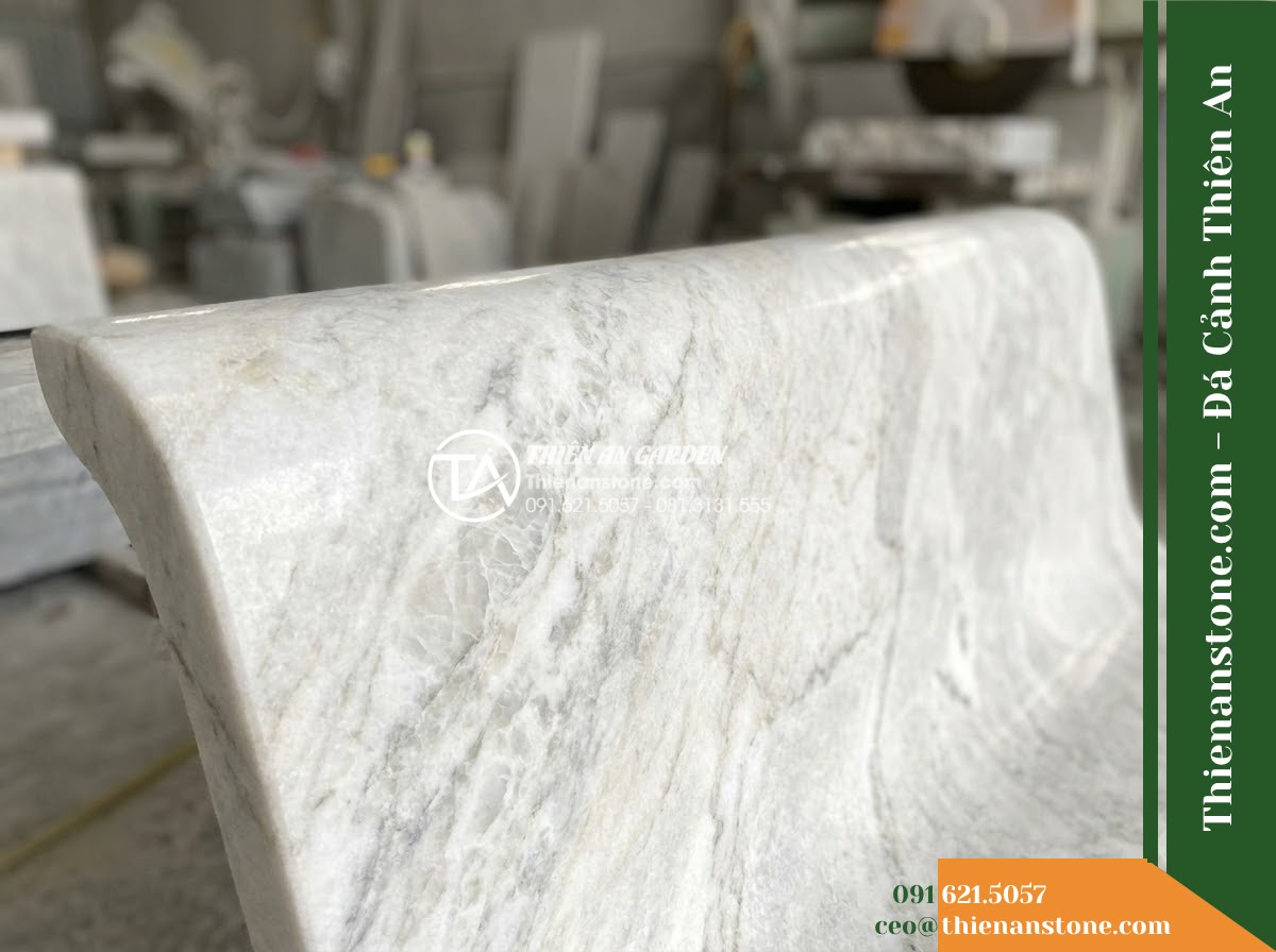 Ghế Đá Granito Phúc Thịnh – Kích thước 170 x 50 x 78 cm – Kiểu dáng tựa nan dọc thưa, hai đầu vuốt cong. Chất liệu đá granito (đá mài) - Hình 2 Ghế Đá Granito Phúc Thịnh – Kích thước 170 x 50 x 78 cm – Kiểu dáng tựa nan dọc thưa, hai đầu vuốt cong. Chất liệu đá granito (đá mài) - A granito polished stone stone bench placed in a lush Vietnamese garden, wide an