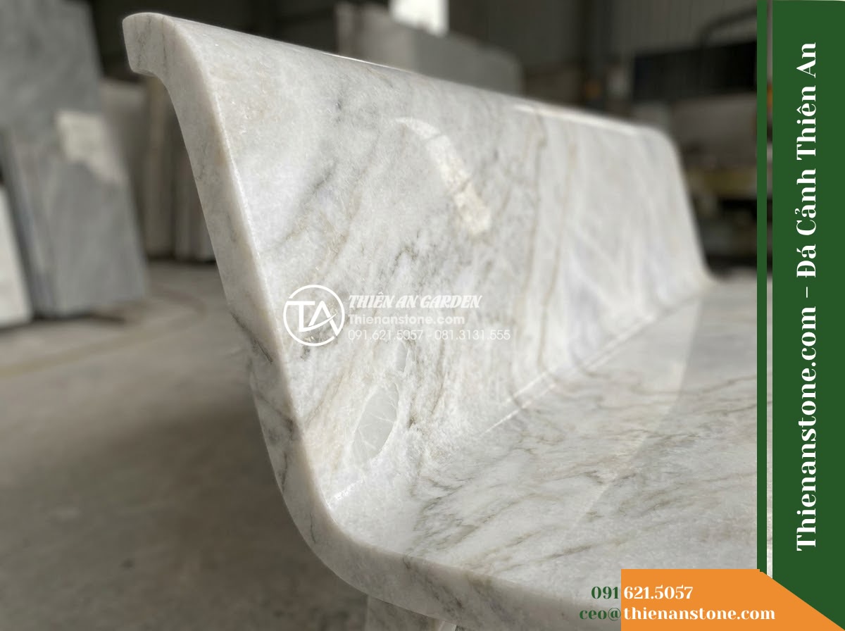 Ghế Đá Granito Thiên Thành – Kích thước 165 x 50 x 80 cm – Kiểu dáng tựa cong thấp, mặt ngồi rộng. Chất liệu đá granito (đá mài) - Hình 1 Ghế Đá Granito Thiên Thành – Kích thước 165 x 50 x 80 cm – Kiểu dáng tựa cong thấp, mặt ngồi rộng. Chất liệu đá granito (đá mài) - Hand touching the surface of a granito polished stone stone bench, showing scale
