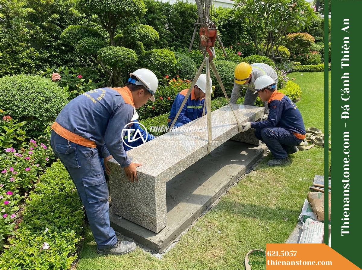 Ghế Đá Granito Vạn Thành – Kích thước 155 x 46 x 45 cm – Kiểu dáng không tựa, mặt dài thanh mảnh. Chất liệu đá granito (đá mài) - Hình 5 Ghế Đá Granito Vạn Thành – Kích thước 155 x 46 x 45 cm – Kiểu dáng không tựa, mặt dài thanh mảnh. Chất liệu đá granito (đá mài) - Professional installation of a granito polished stone stone bench in a landscape