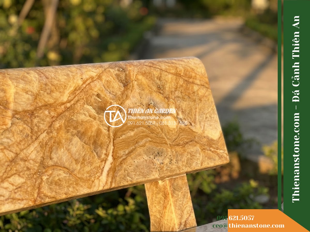 Ghế Đá Sân Trường Ánh Dương – Kích thước 175 x 50 x 80 cm – Kiểu dáng tựa thẳng liền tấm, chân vuông. Chất liệu đá vàng cẩm thạch - Hình 3 Ghế Đá Sân Trường Ánh Dương – Kích thước 175 x 50 x 80 cm – Kiểu dáng tựa thẳng liền tấm, chân vuông. Chất liệu đá vàng cẩm thạch - A golden marble stone bench at golden hour, warm sunset light casting long shado