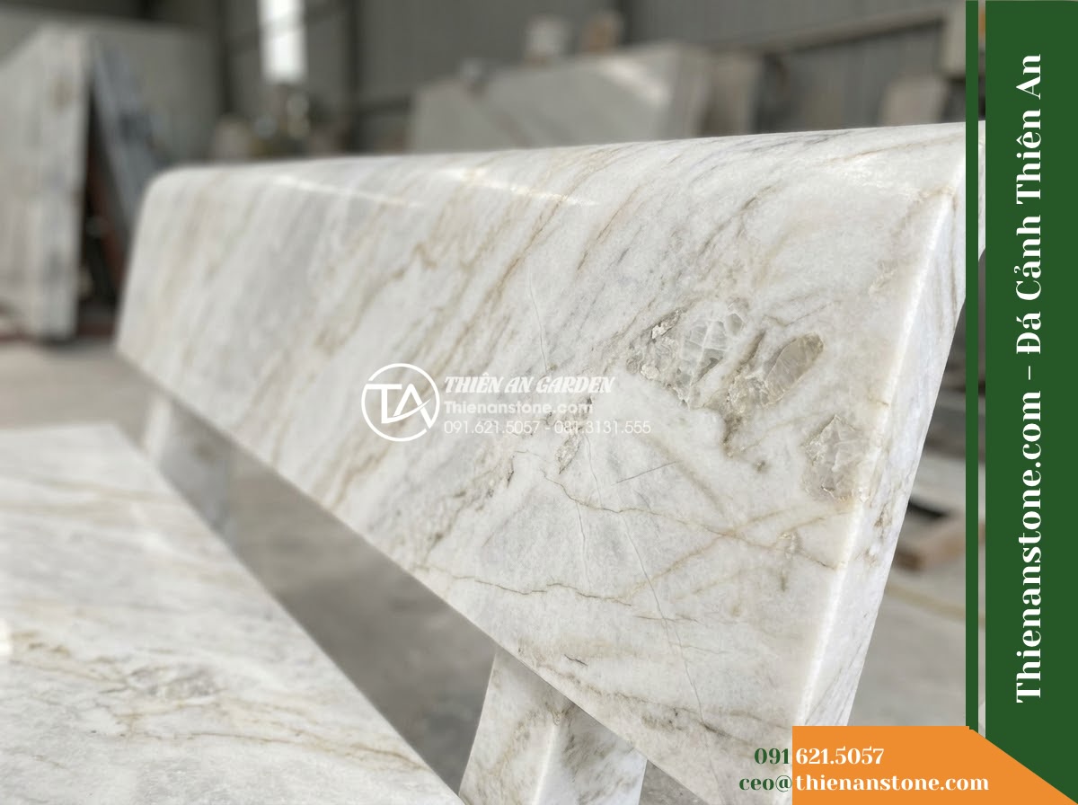 Ghế Đá Sân Trường Ánh Dương – Kích thước 175 x 50 x 80 cm – Kiểu dáng tựa thẳng liền tấm, chân vuông. Chất liệu đá vàng cẩm thạch - Hình 4 Ghế Đá Sân Trường Ánh Dương – Kích thước 175 x 50 x 80 cm – Kiểu dáng tựa thẳng liền tấm, chân vuông. Chất liệu đá vàng cẩm thạch - A golden marble stone bench integrated into a Vietnamese luxury resort landscape
