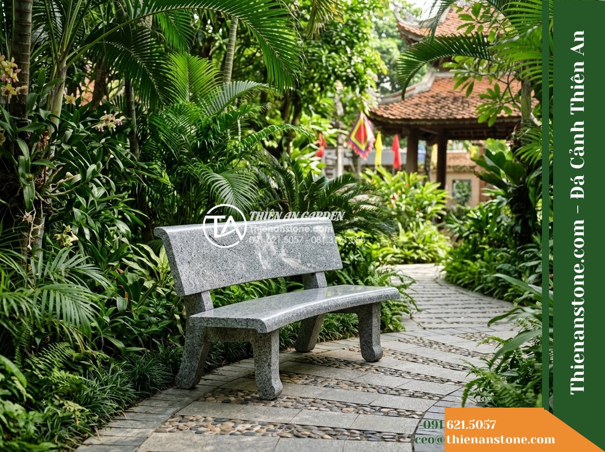 Ghế Đá Sân Trường Chăm Ngoan – Kích thước 145 x 44 x 45 cm – Kiểu dáng nhỏ gọn, chân trụ thấp. Chất liệu đá hoa cương - Hình 2 Ghế Đá Sân Trường Chăm Ngoan – Kích thước 145 x 44 x 45 cm – Kiểu dáng nhỏ gọn, chân trụ thấp. Chất liệu đá hoa cương - A granite stone bench placed in a lush Vietnamese garden, wide angle shot showin