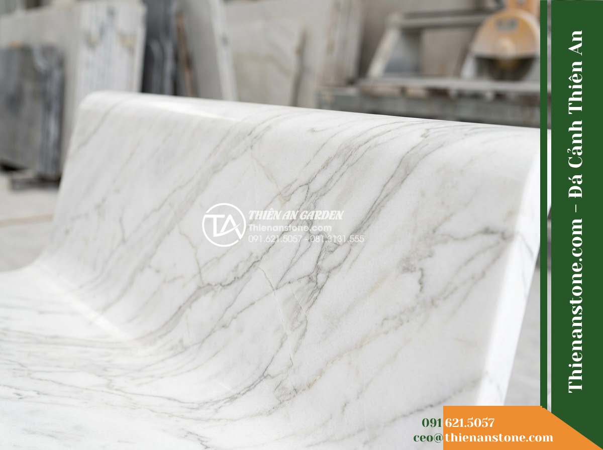 Ghế Đá Sân Trường Hiếu Học – Kích thước 165 x 48 x 80 cm – Kiểu dáng tựa cong ôm lưng, chân vuông. Chất liệu đá vàng cẩm thạch - Hình 2 Ghế Đá Sân Trường Hiếu Học – Kích thước 165 x 48 x 80 cm – Kiểu dáng tựa cong ôm lưng, chân vuông. Chất liệu đá vàng cẩm thạch - Elegant golden marble stone bench in a school courtyard, flanked by phoenix flow