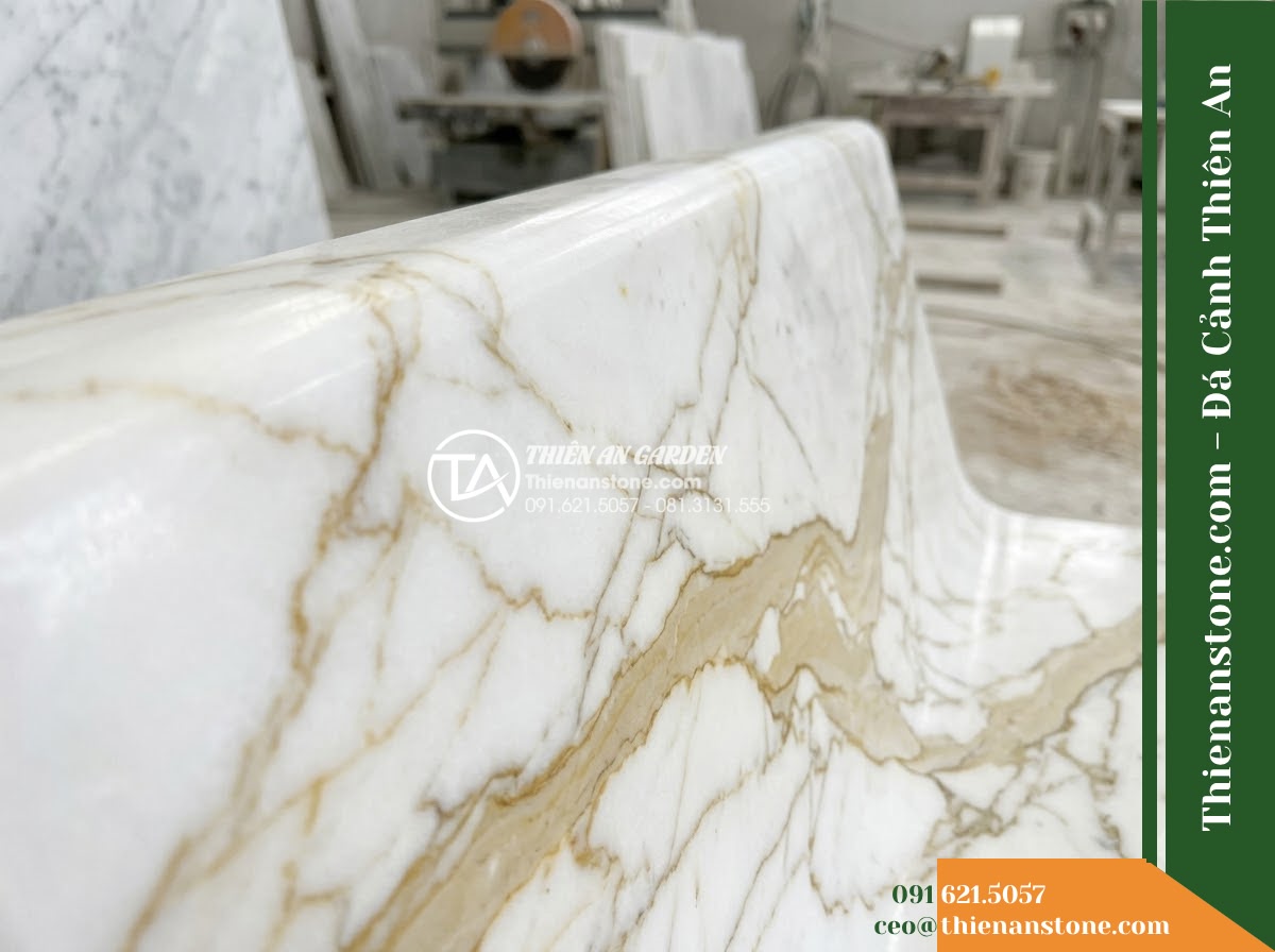 Ghế Đá Sân Trường Tân Tiến – Kích thước 160 x 48 x 78 cm – Kiểu dáng tựa nan ngang thấp, mặt rộng. Chất liệu đá vàng cẩm thạch - Hình 5 Ghế Đá Sân Trường Tân Tiến – Kích thước 160 x 48 x 78 cm – Kiểu dáng tựa nan ngang thấp, mặt rộng. Chất liệu đá vàng cẩm thạch - Professional installation of a golden marble stone bench in a landscaped garden,