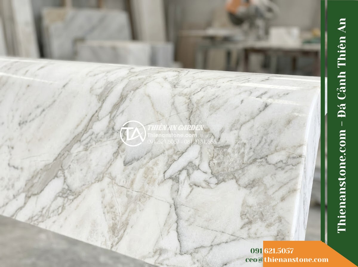 Ghế Đá Sân Trường Thành Nhân – Kích thước 185 x 50 x 80 cm – Kiểu dáng tựa liền rộng, tay vịn thấp. Chất liệu đá hoa cương - Hình 3 Ghế Đá Sân Trường Thành Nhân – Kích thước 185 x 50 x 80 cm – Kiểu dáng tựa liền rộng, tay vịn thấp. Chất liệu đá hoa cương - Autumn scene with fallen leaves scattered on a granite stone bench in a peaceful