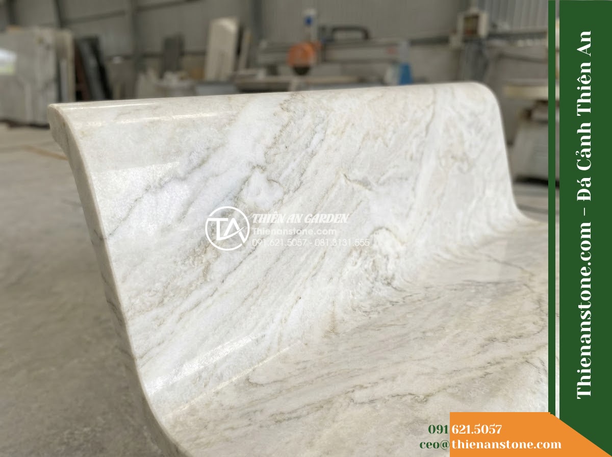 Ghế Đá Sân Trường Tri Thức – Kích thước 170 x 48 x 80 cm – Kiểu dáng tựa nan dọc, mặt ngồi rộng. Chất liệu đá hoa cương - Hình 3 Ghế Đá Sân Trường Tri Thức – Kích thước 170 x 48 x 80 cm – Kiểu dáng tựa nan dọc, mặt ngồi rộng. Chất liệu đá hoa cương - Autumn scene with fallen leaves scattered on a granite stone bench in a peaceful